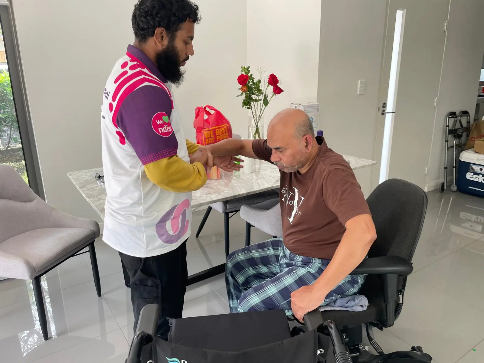 Optimal Care support worker assisting a participant with a meal at home