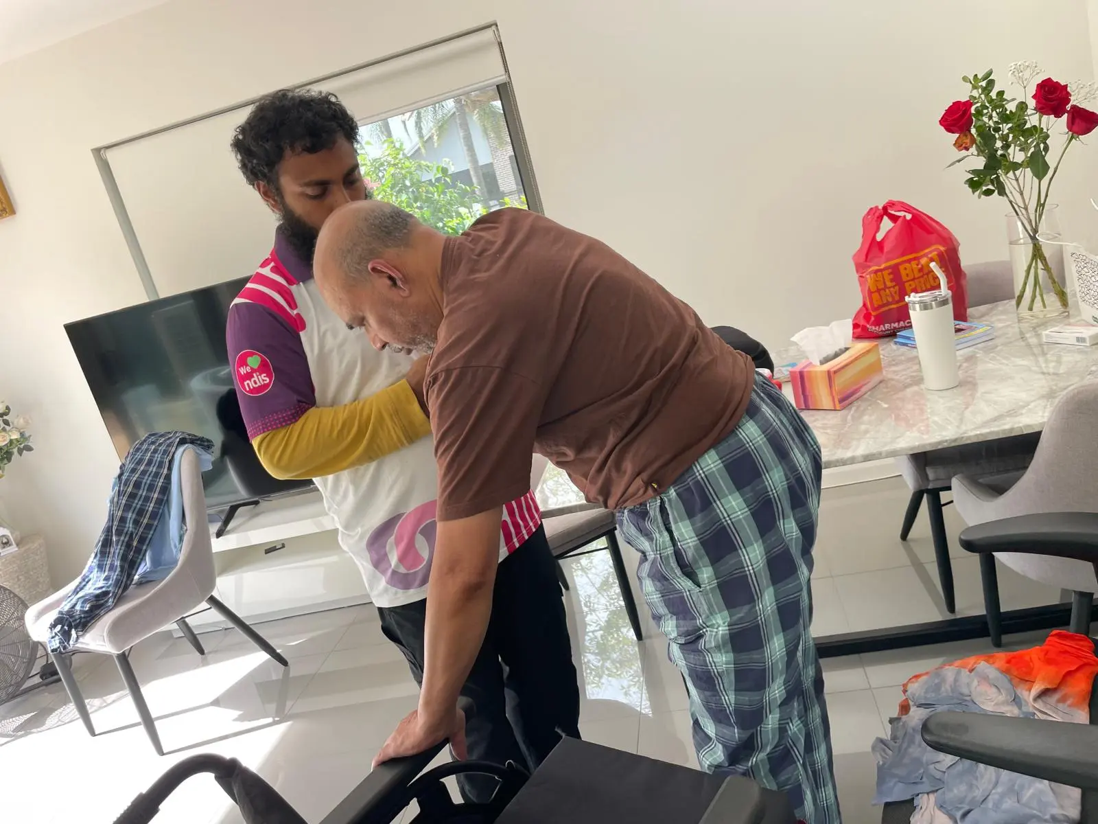 Support worker helping a participant at home during a support session
