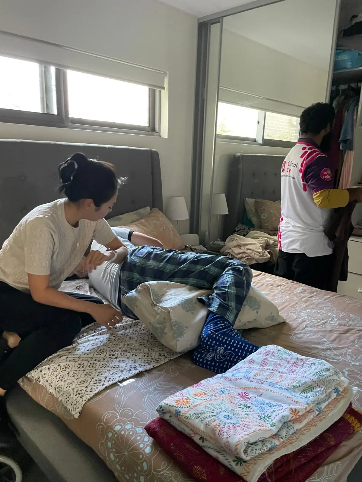 Support worker making a participant's bed during a home visit